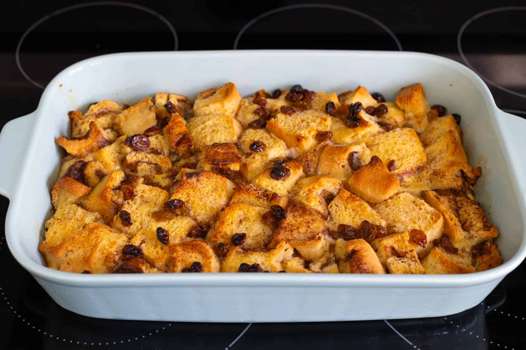 The cinnamon roll casserole has just come out of the oven and is golden brown on top.