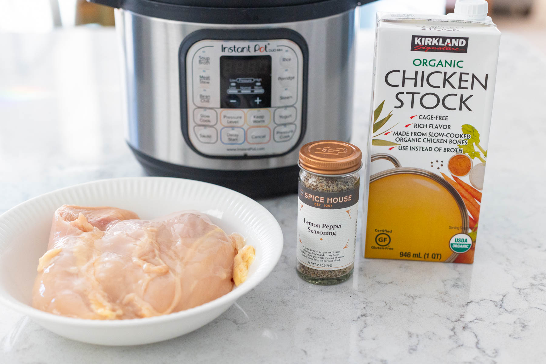 The ingredients to make the shredded chicken are sitting in front of the Instant Pot.