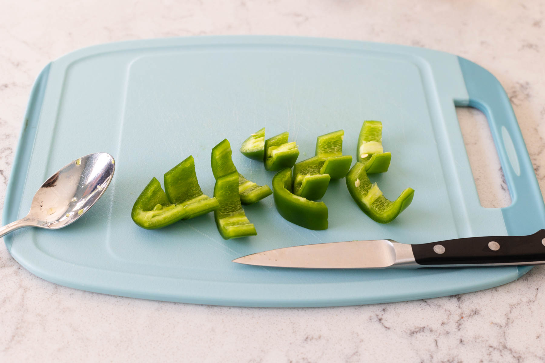 The Jalapeño pepper is on a cutting board.