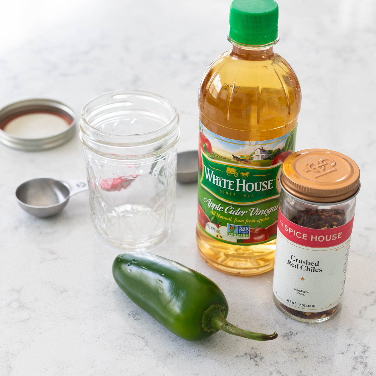 The ingredients to make homemade peppered vinegar are on the counter.