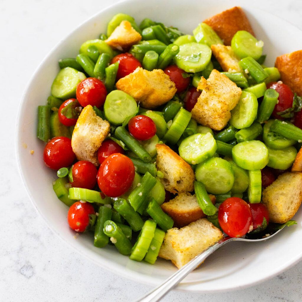 A bowl of raw vegetables with croutons.