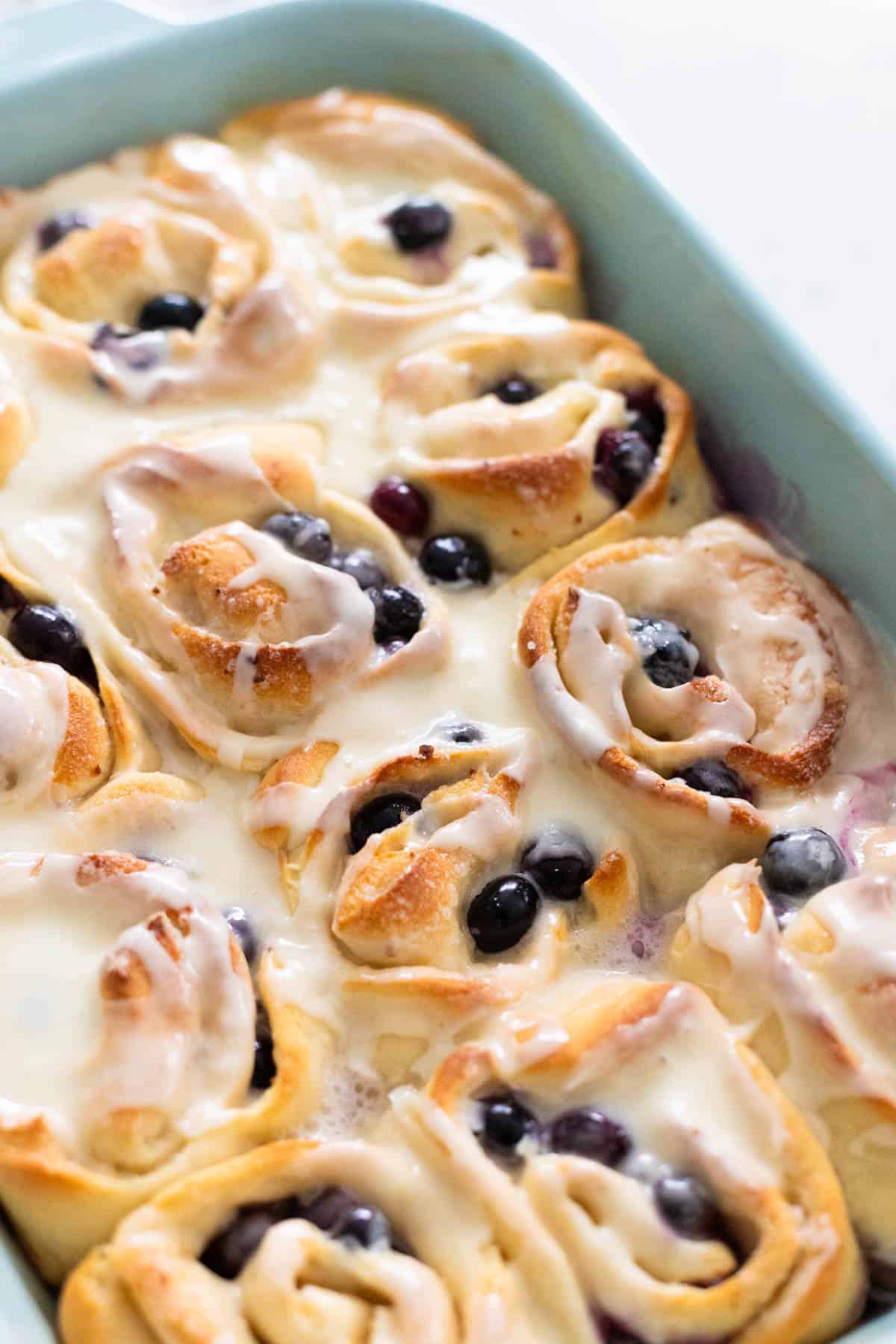 The pan of blueberry rolls have been glazed with the citrus glaze.