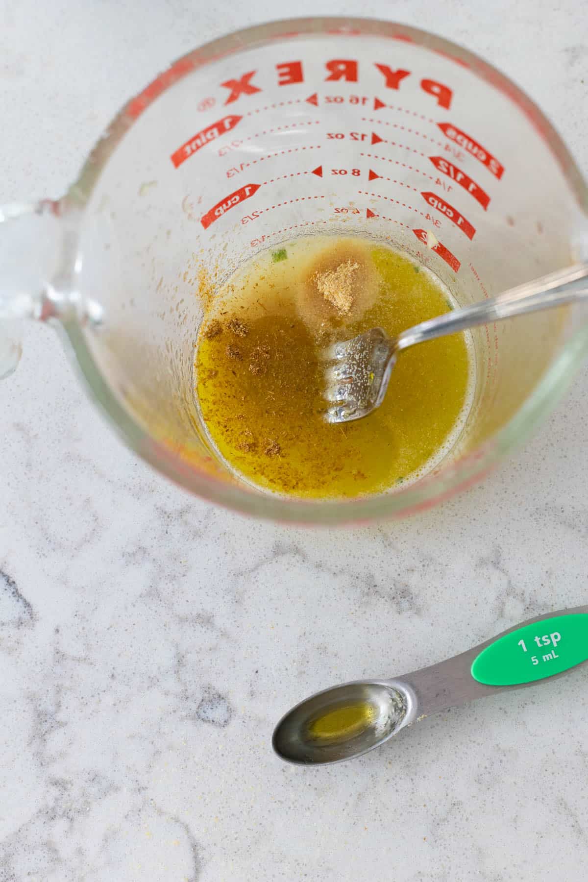 The measuring cup has the oil and lime juice with seasonings.