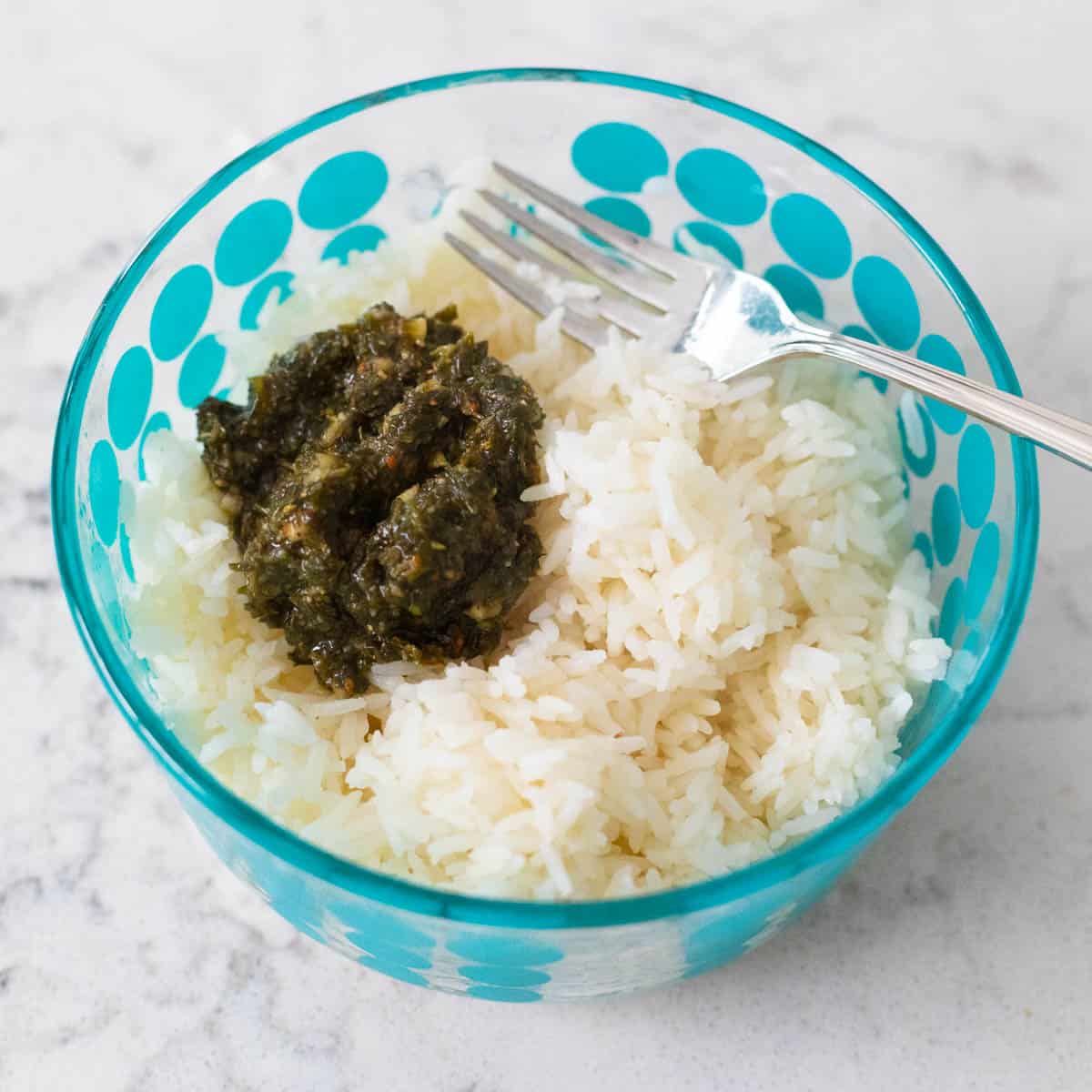 The chimichurri sauce has been spooned into a bowl of white rice.