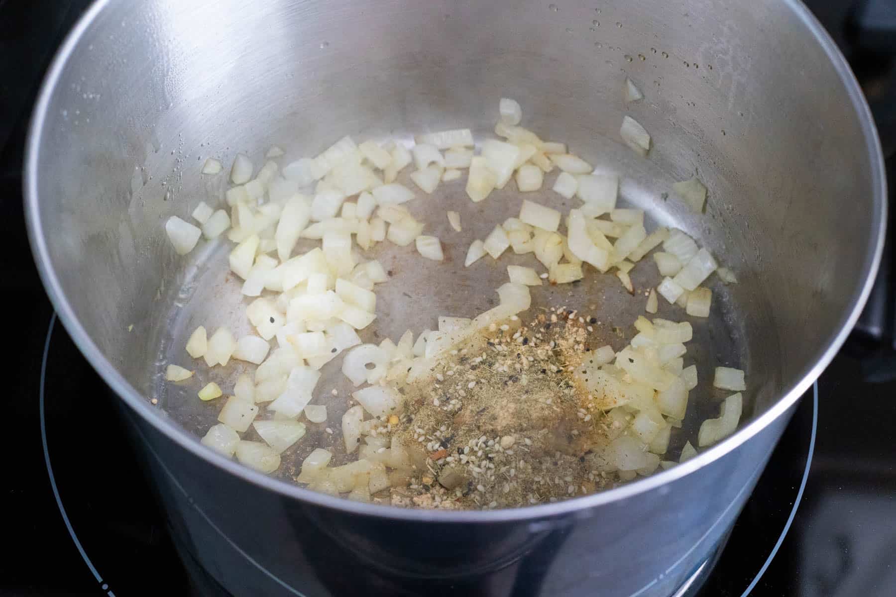 The diced onion and seasonings have been added to the pot.