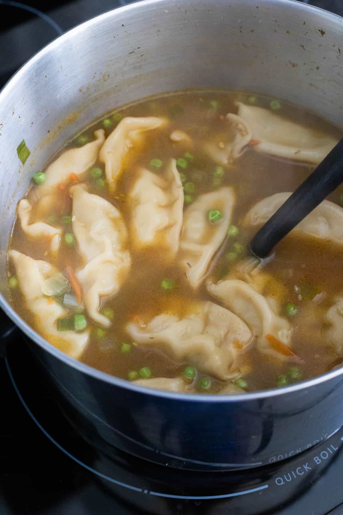 The frozen potstickers have been added to the broth.