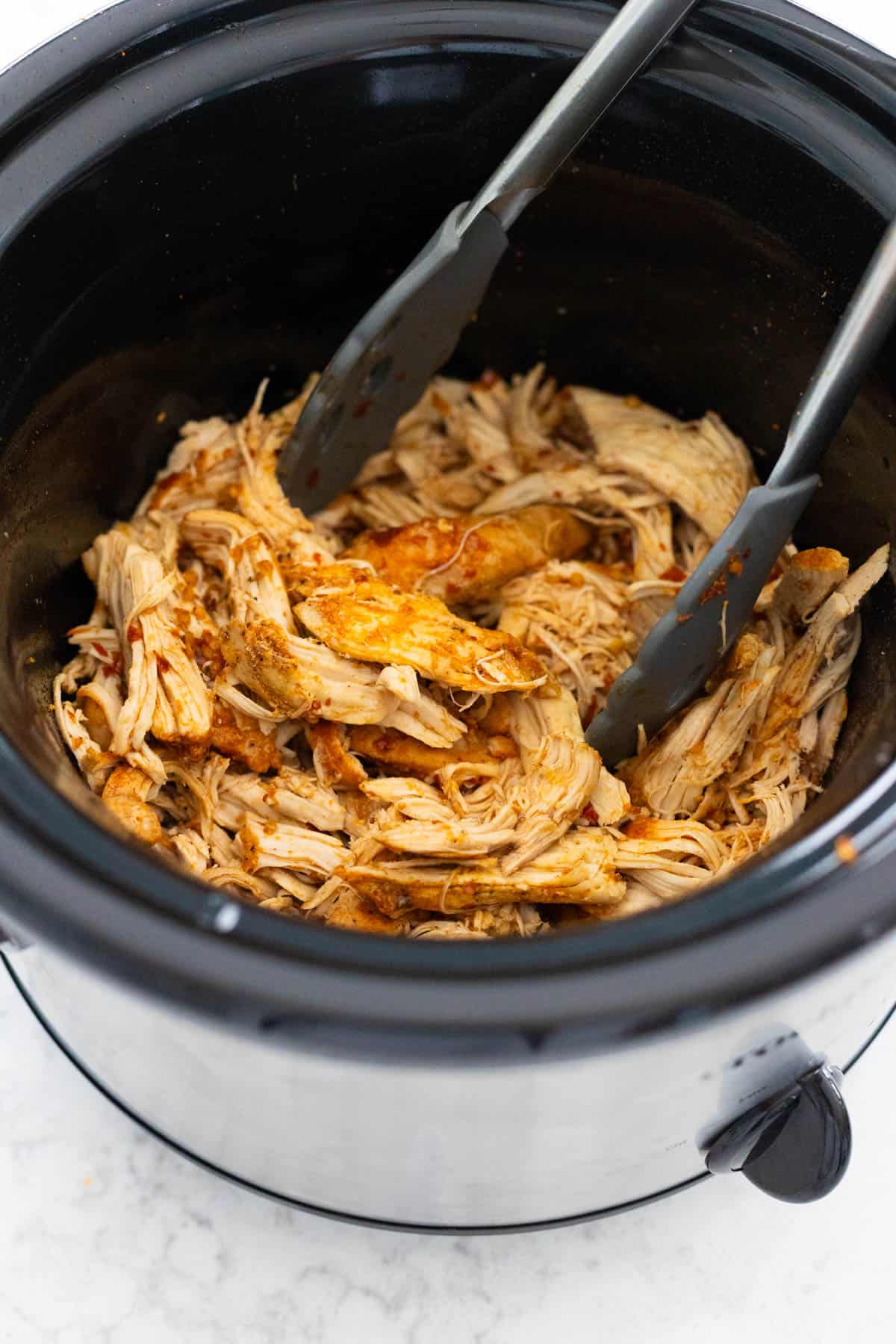 The hot honey chicken has been coated in the sauce inside the Crockpot.