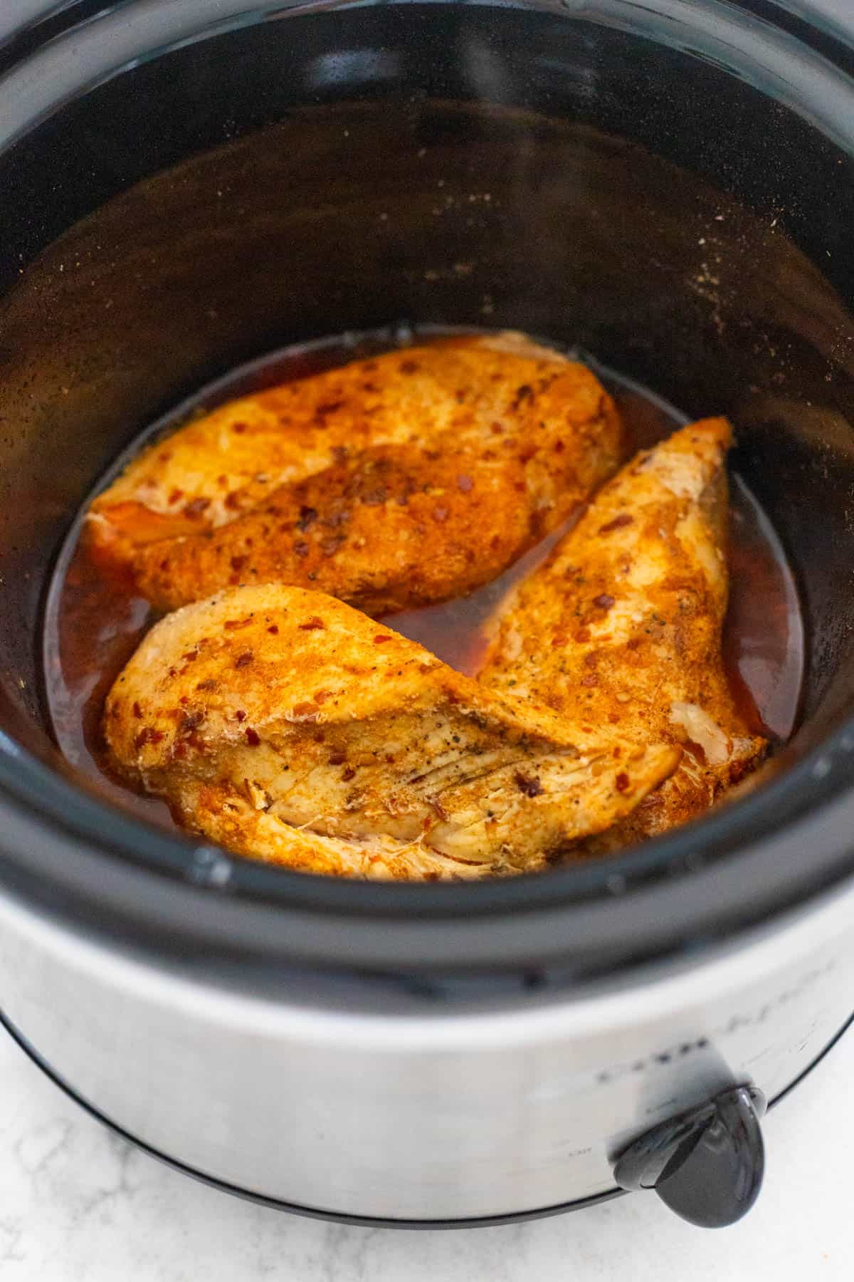 The chicken breasts have been fully cooked inside the Crockpot and are ready to be shredded.